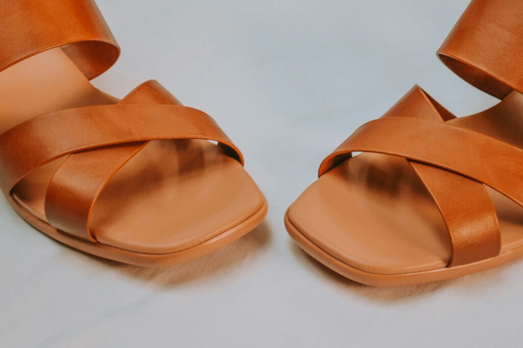 A pair of brown leather sandals photographed from above